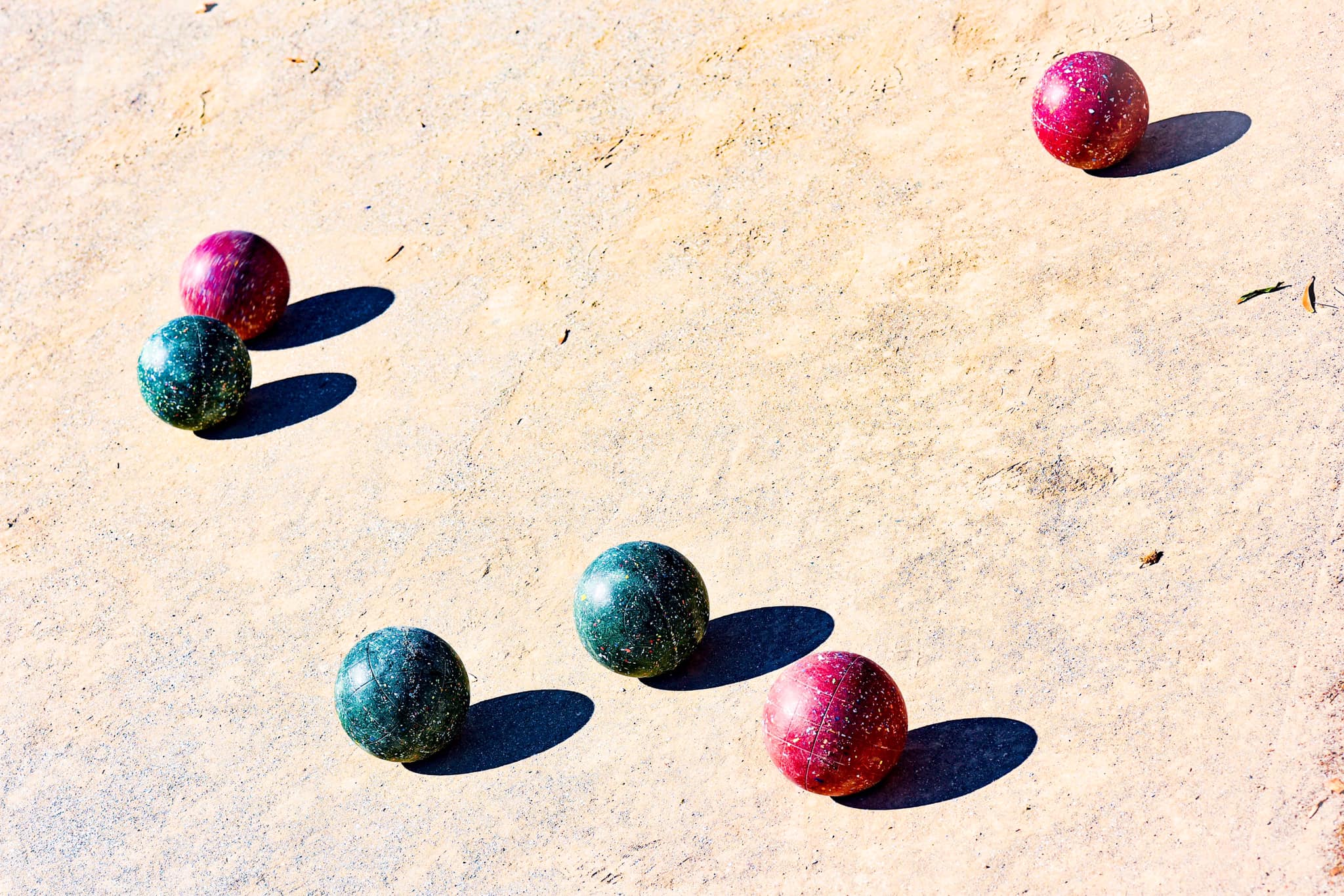 Bocce balls lying in the middle of a bocce ball court